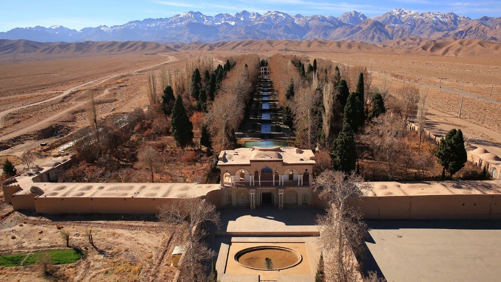 نمایی از یک باغ میان بیابان که با سیستم قنات سنتی ایرانی آبرسانی شده