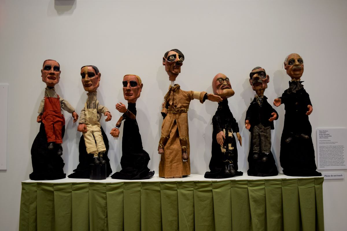 یک میز که ردیفی از عروسک های کاریکتوری جنگ جهانی دوم از جمله آدولف هیتلر روی آن قرار دارند